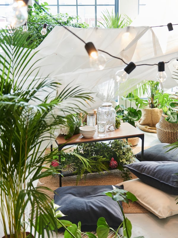 Una taula de centre FJÄLLBO en un menjador ple de plantes i vegetació.