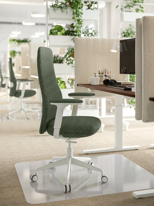 Workstations in an office have beige, sand-like MITTZON acoustic screens for desks and grey-green GRÖNFJÄLL office chairs.