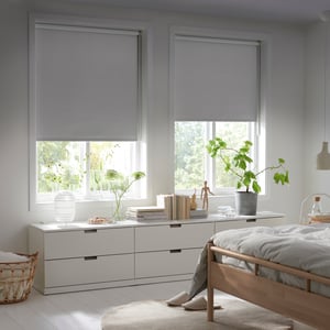 FRIDANS blackout roller blinds in a bright, calm bedroom.