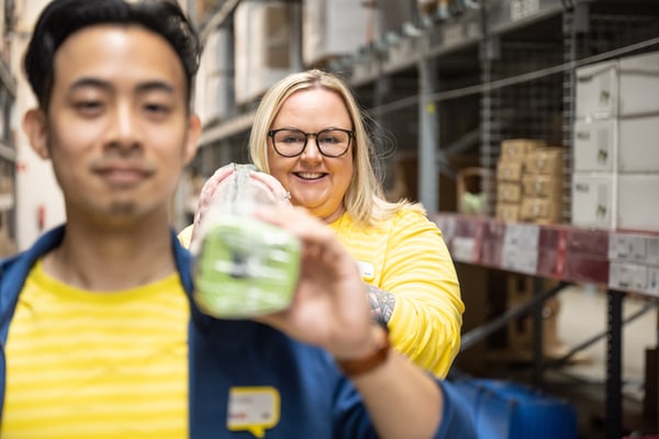 Two IKEA co-workers carrying a package.