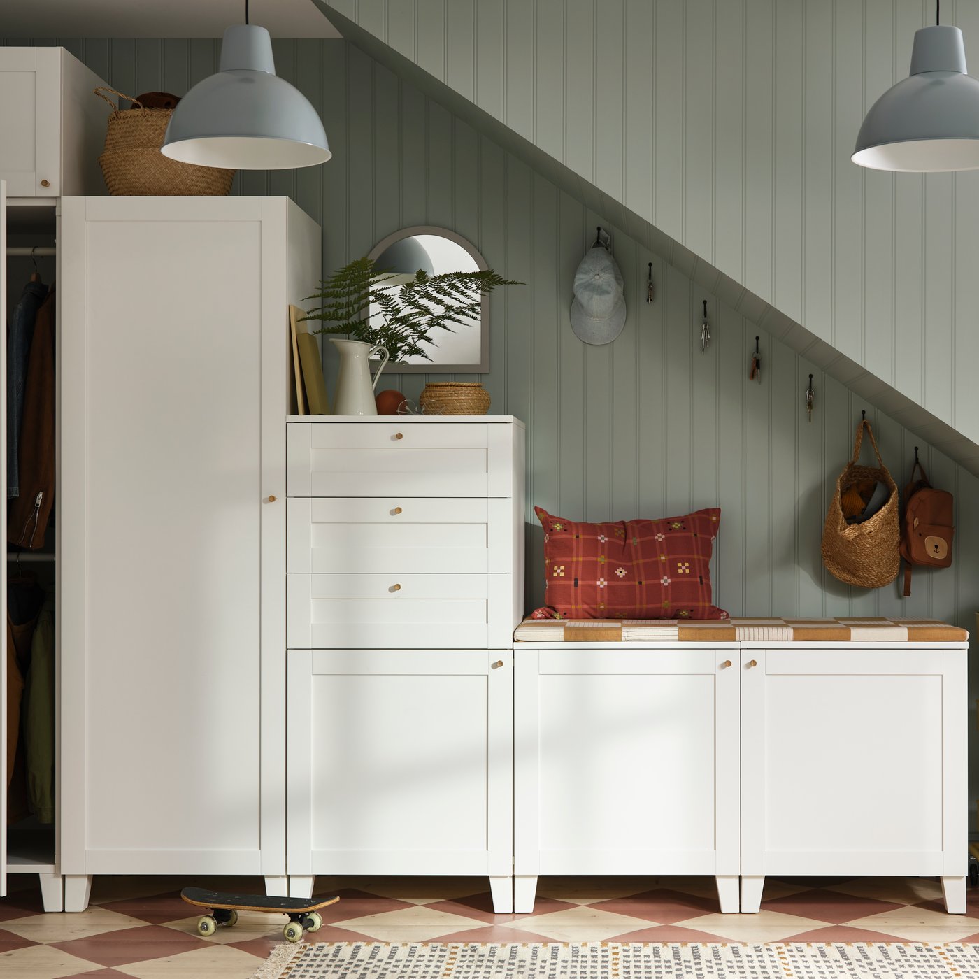 Mehrere weiße PLATSA Schränke in verschiedenen Höhen unter einem Stiegenaufgang.