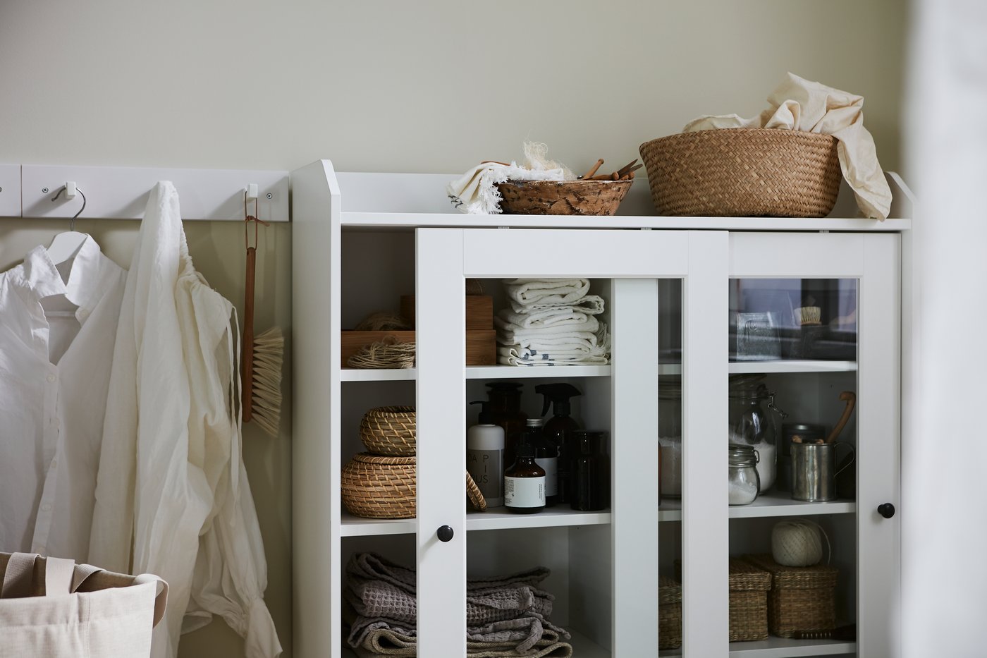 A white HAUGA glass-door cabinet in the bathroom