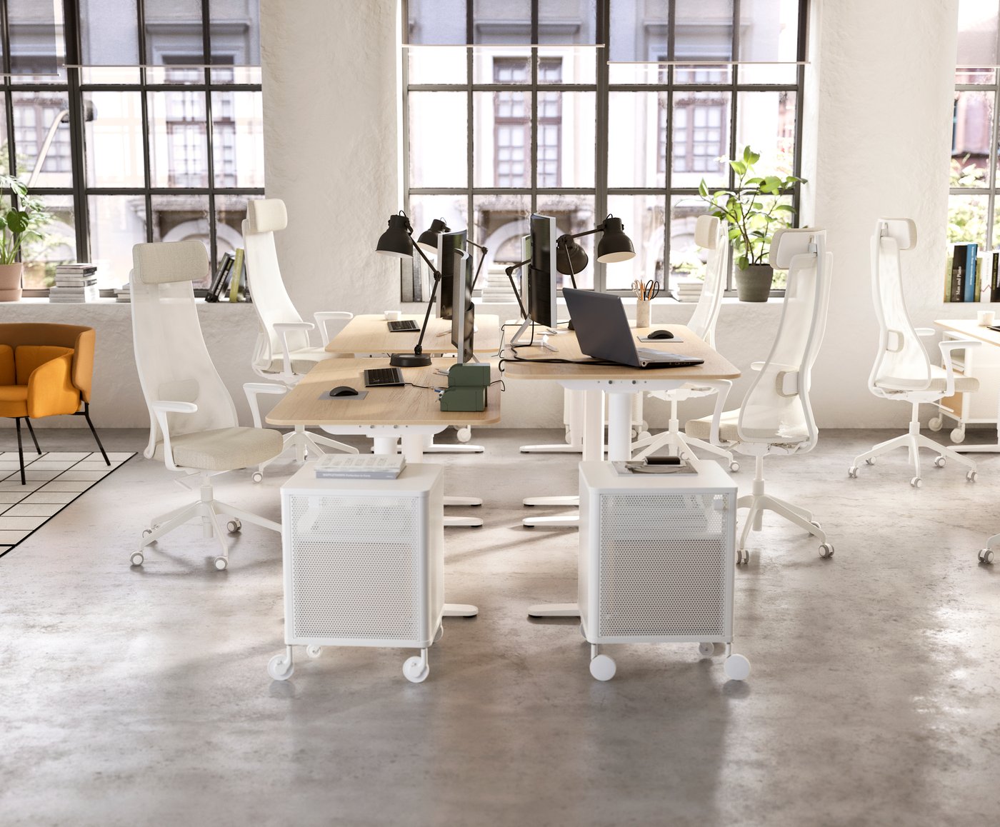 Et åbent kontorlandskab med 4 skriveborde, 4 stole og 4 lamper.