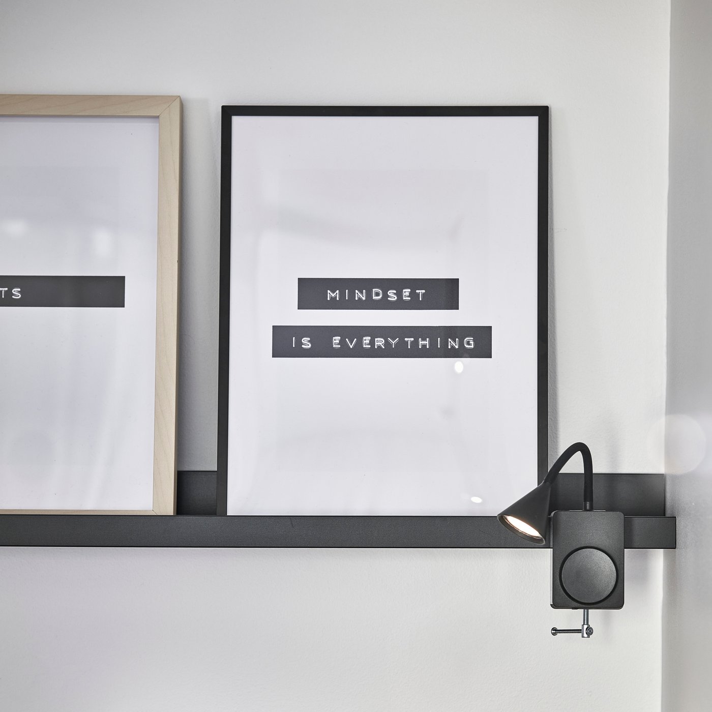 Inramade posters och tavlor lutade mot en vägg i en stilren inredning.