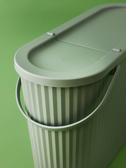 Spălătorie cu o pubelă ovală DAMMÄNG cu capac din plastic polipropilenic și mâner din plastic poliamidic armat.