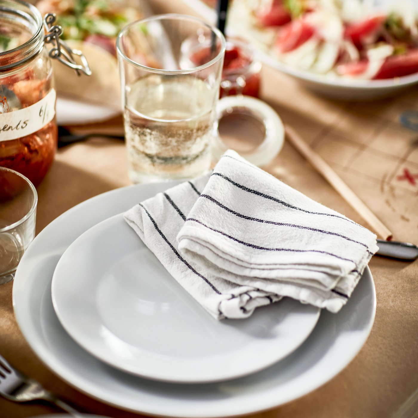 Un servizio IKEA 365+ bianco da 18 pezzi e uno strofinaccio bianco a righe nere