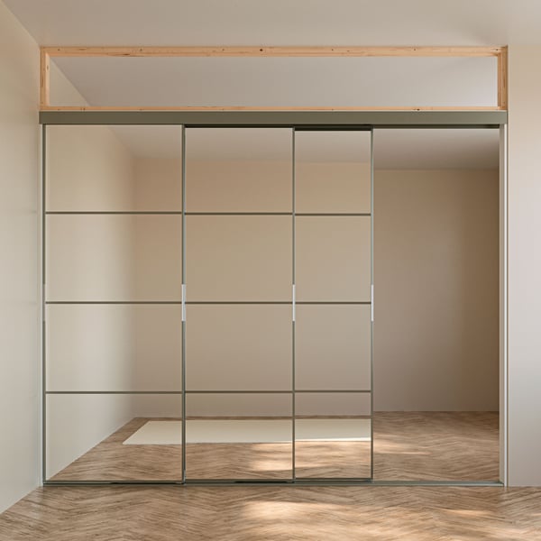 A SKYTTA sliding door solution with a SKYTTA ceiling height reducer mounted between the door frames and the ceiling.