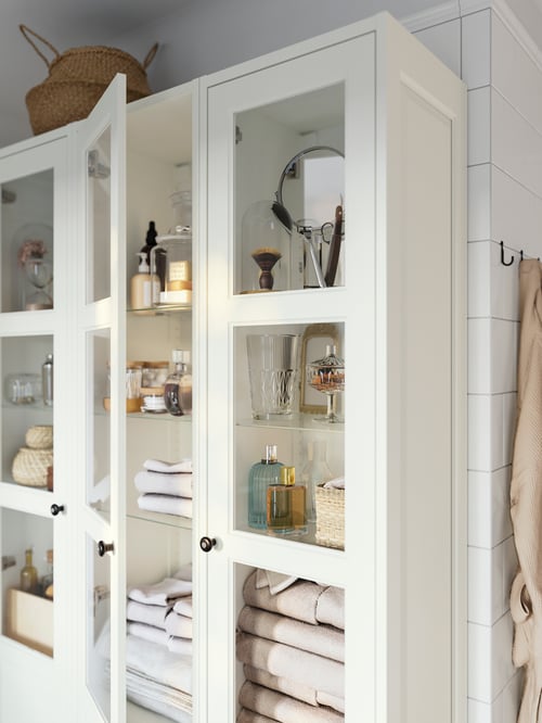 Bathroom corner featuring multiple white TÄNNFORSEN high cabinets with doors with multiple grey KLINGSTORP knobs.