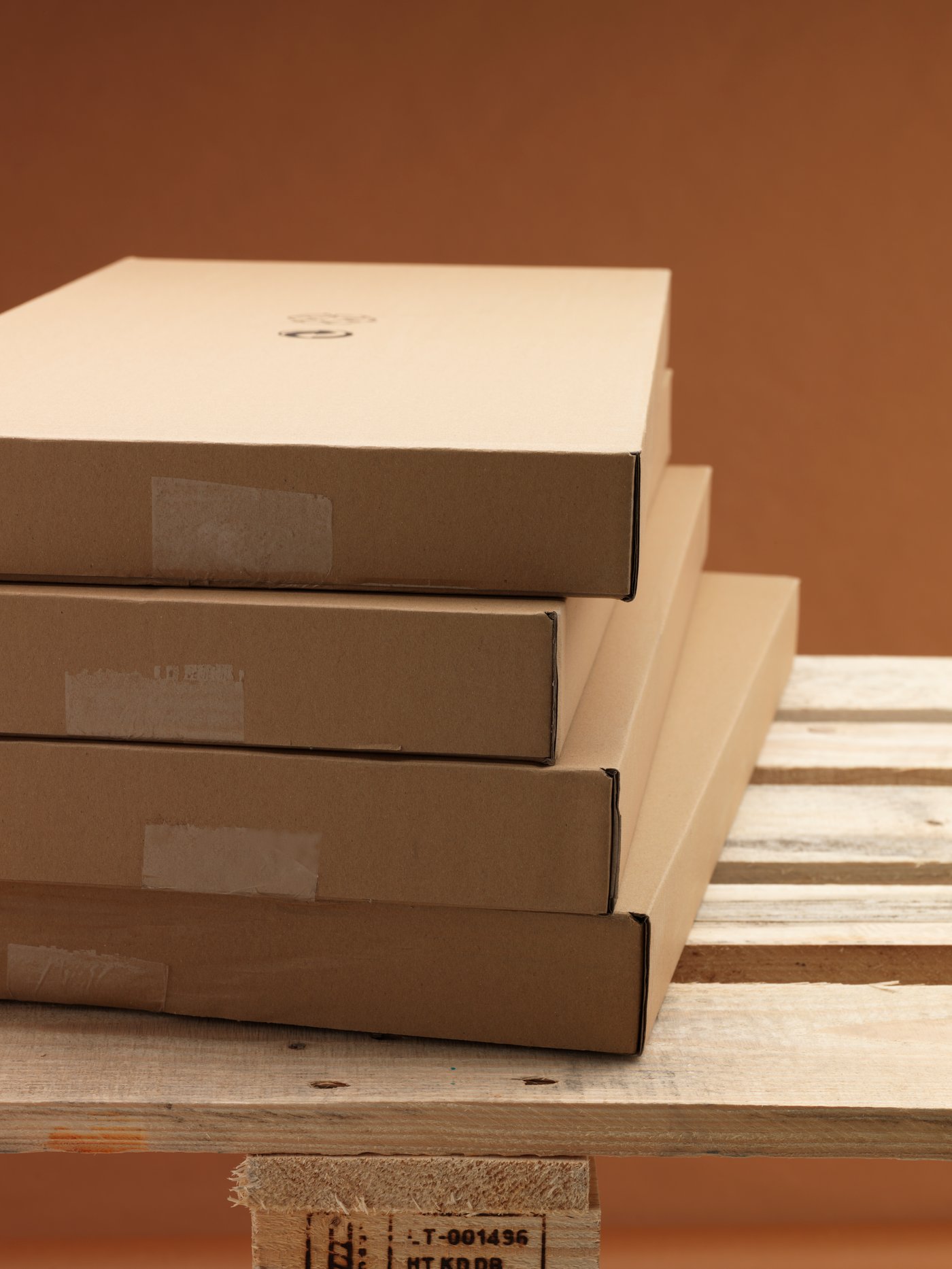 Four IKEA flat packs fashioned from recycled cardboard stacked in an orderly pile on a wooden delivery pallet.