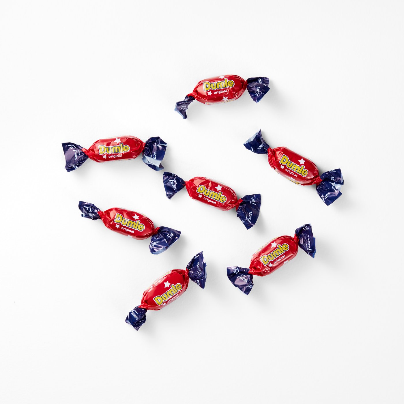 Osam crvenih i plavih omotanih bombona marke Dumle raspoređenih na bijeloj podlozi.