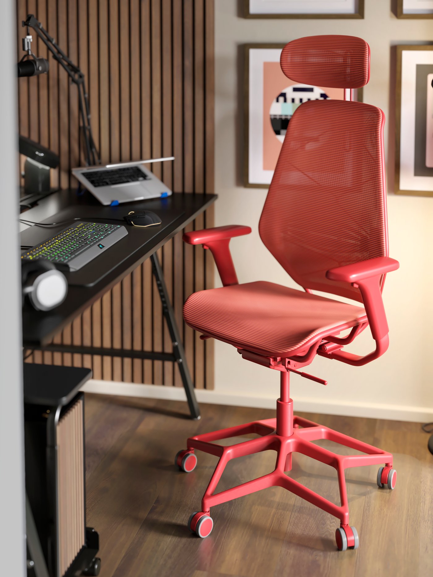 A red STYRSPEL gaming chair is in front of a UTESPELARE gaming desk. A laptop and LÅNESPELARE laptop support are on the desk.
