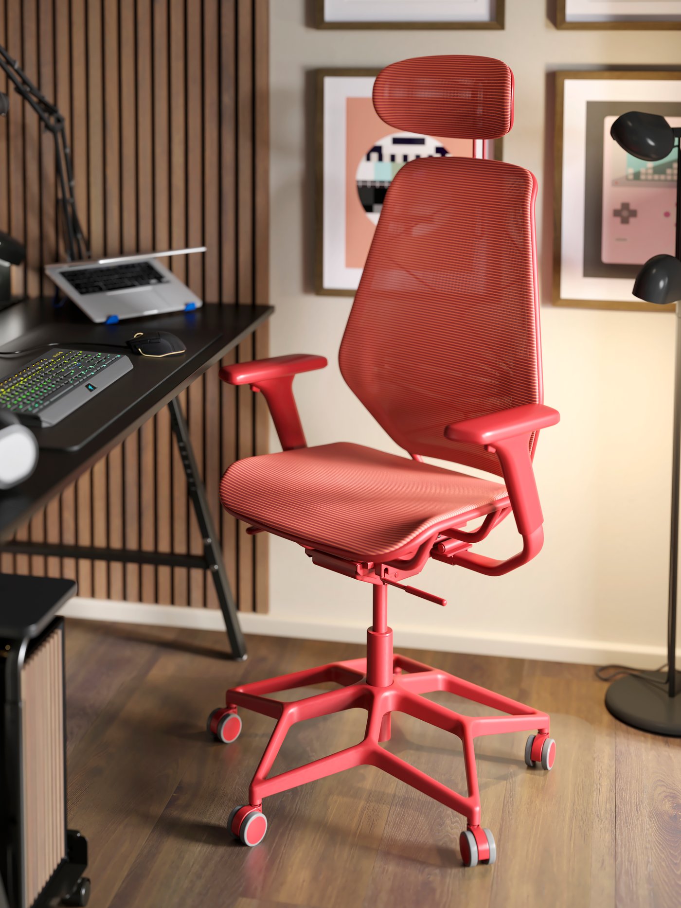 Ein roter STYRSPEL Gaming-Stuhl steht vor einem UTESPELARE Gaming-Schreibtisch. Auf dem Schreibtisch befinden sich ein Laptop und eine LÅNESPELARE Laptop-Halterung.