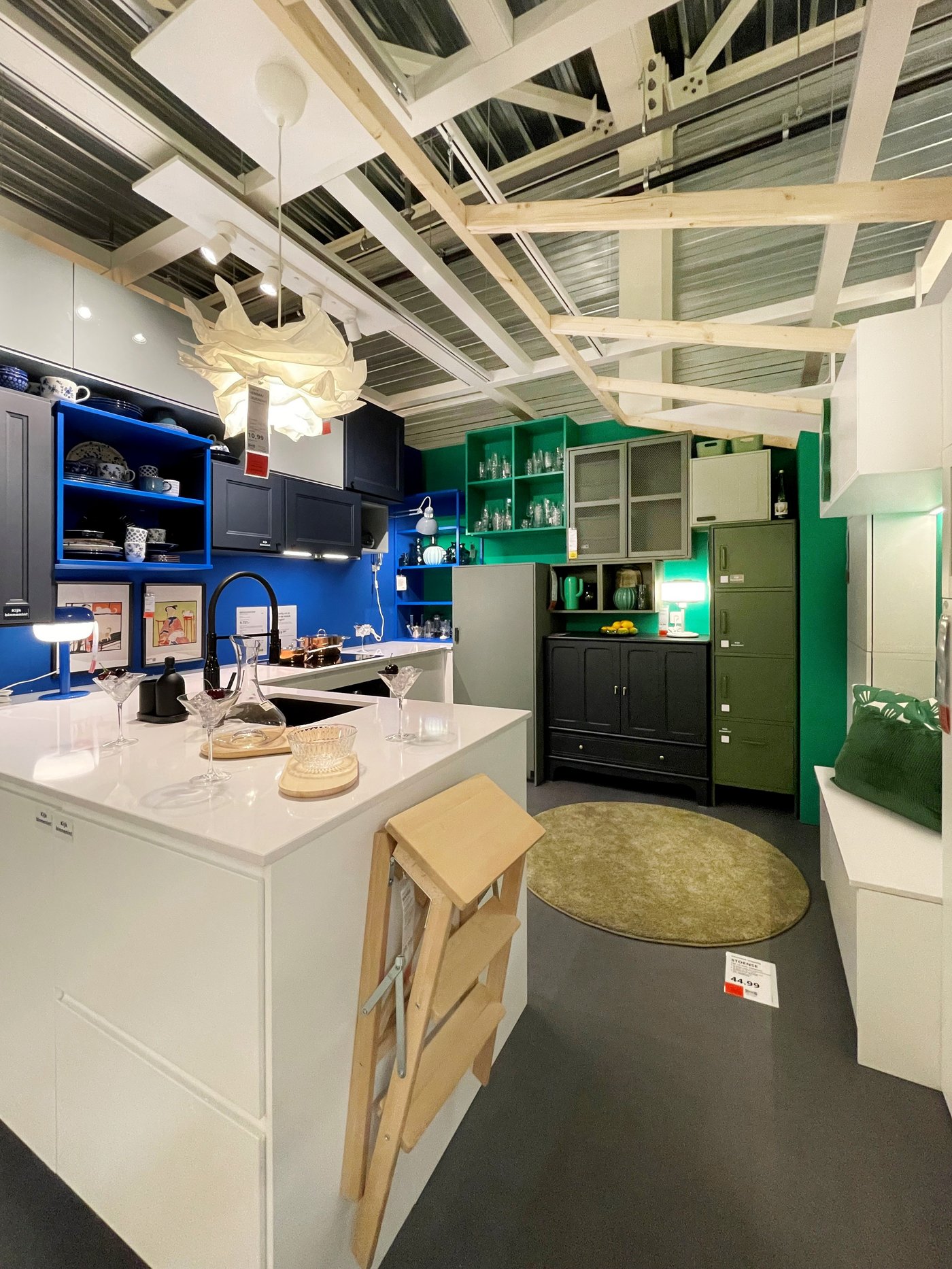 Een witte keuken met blauwe en groene muren en extra kasten.