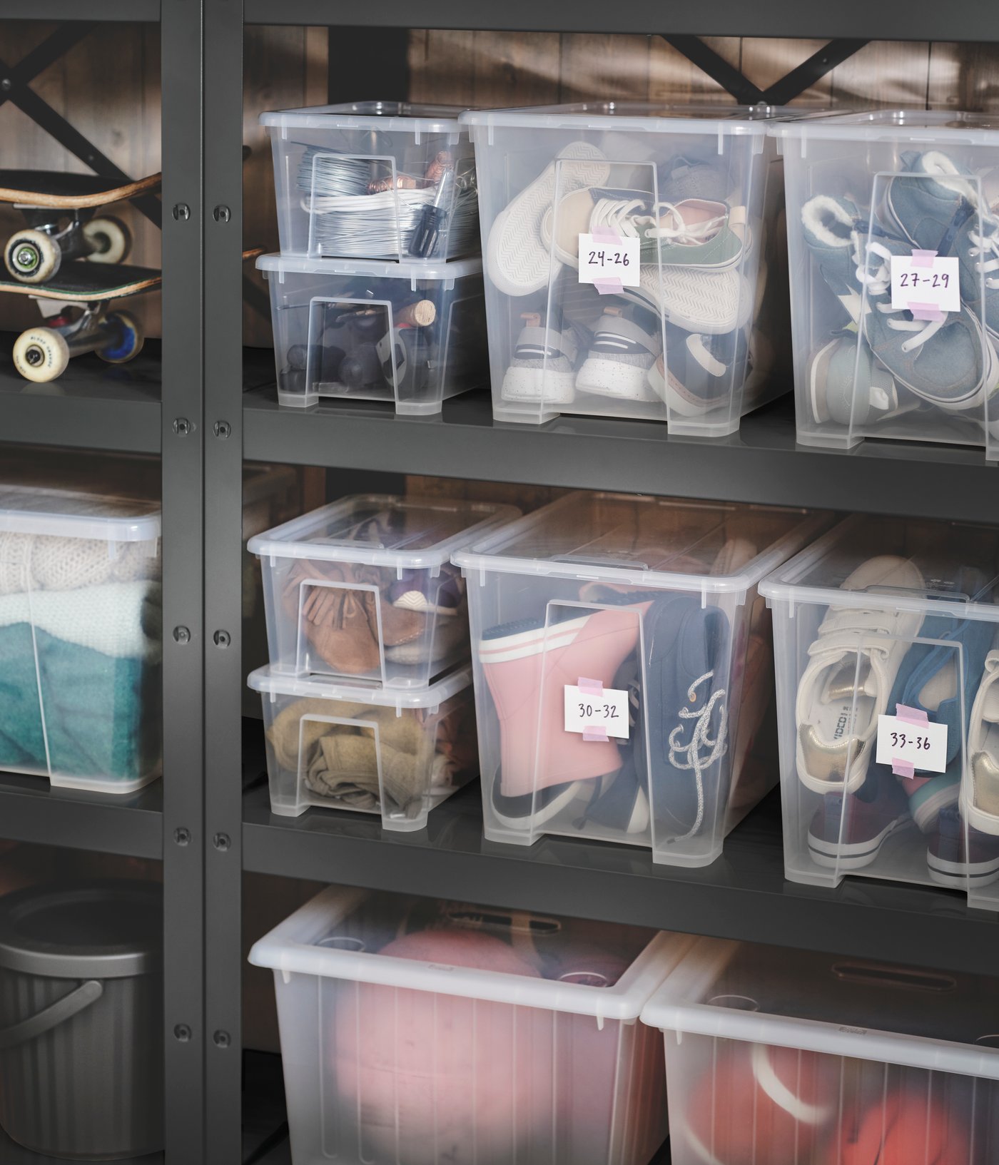 Two black BROR shelving units placed against a wall, holding different-sized SAMLA boxes with lid filled with shoes.