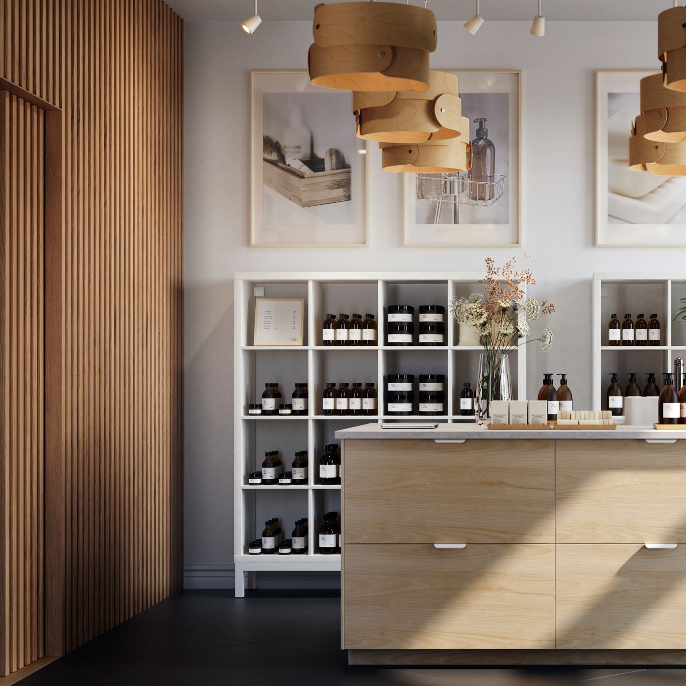 A bright, spacious store interior centred round a large kitchen island with light-ash-effect ASKERSUND drawer fronts.