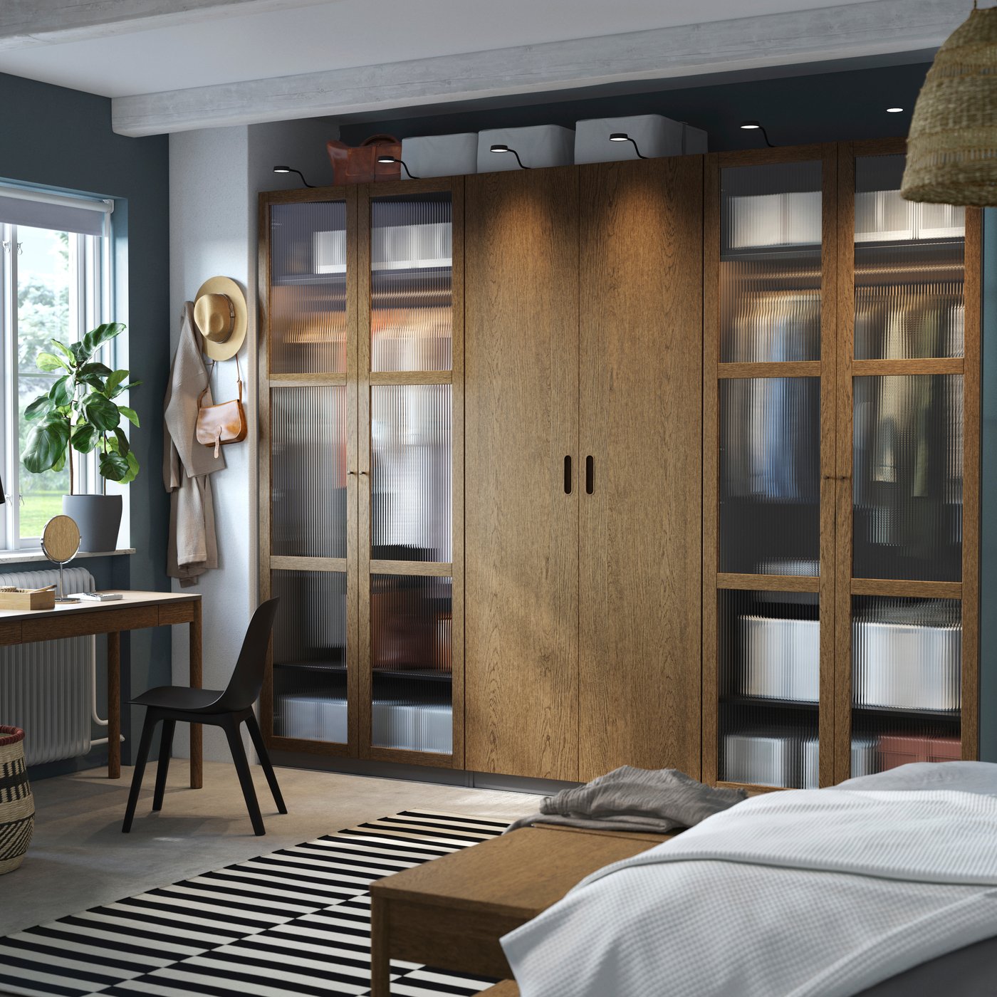 A dark grey brown/stained oak veneer glass PAX wardrobe combination in the bedroom