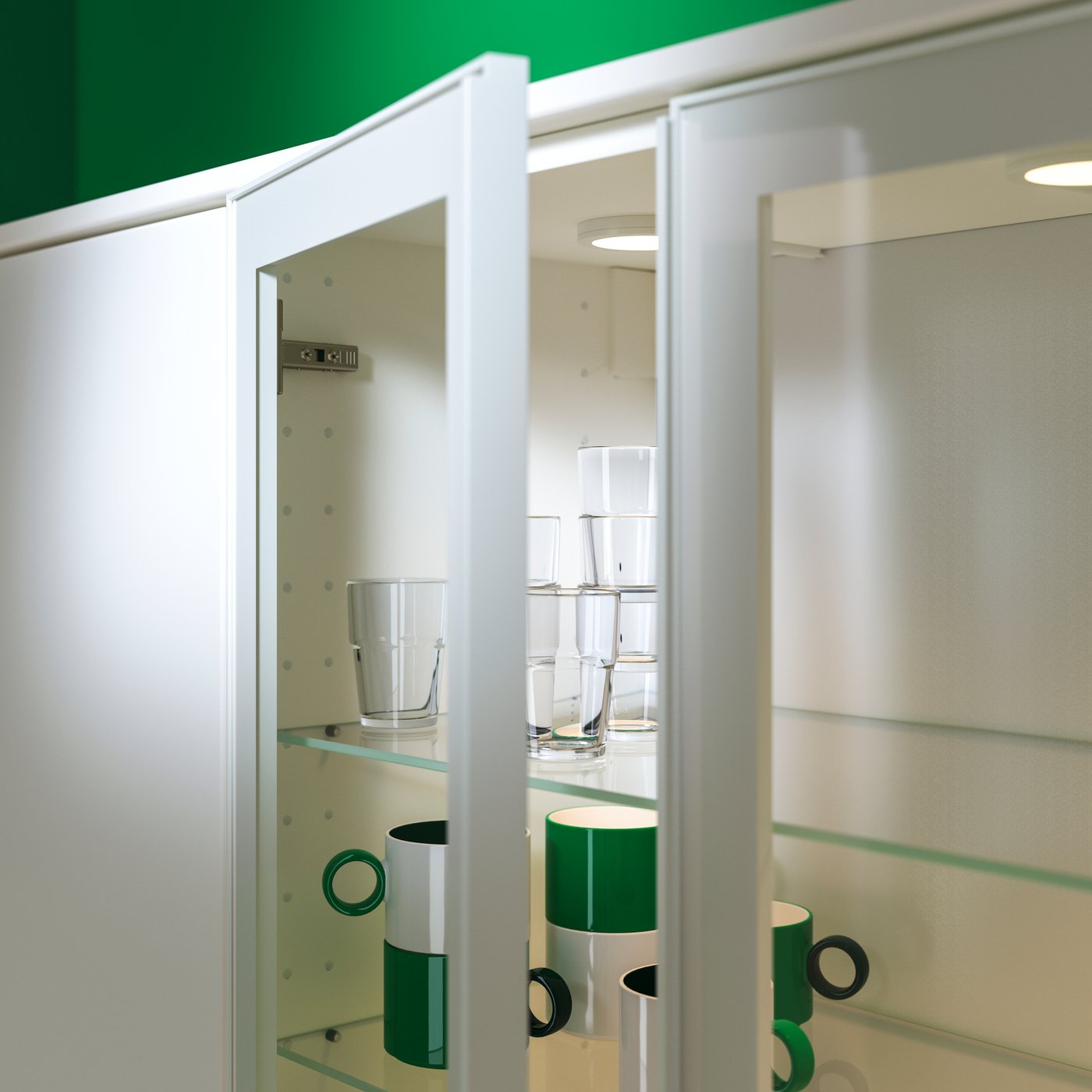 Un pensile con una delle ante a vetro aperta. Sui ripiani in vetro al suo interno sono organizzati bicchieri e tazze verdi e bianche.