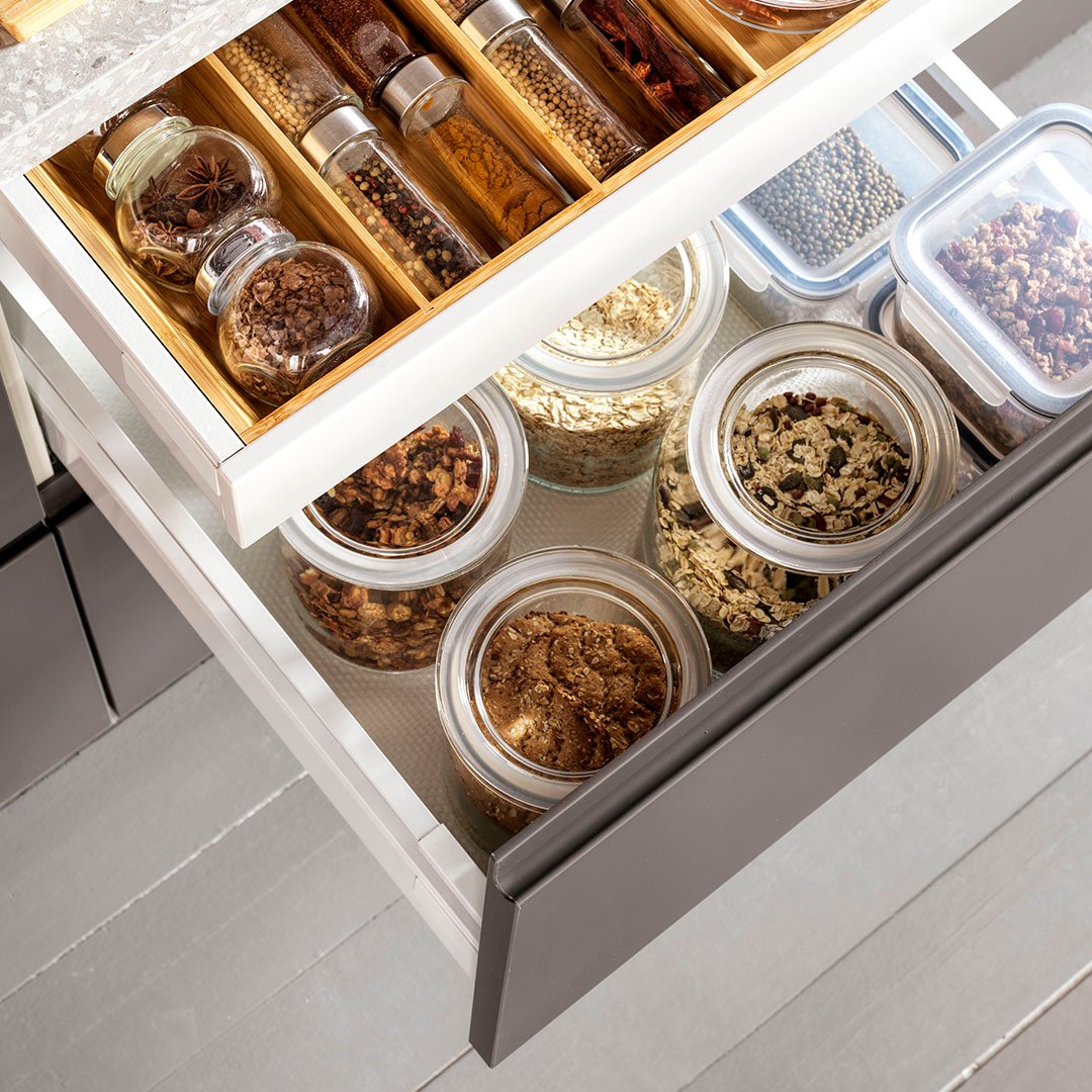 Detalle de un cajón abierto con latas, frascos y especias organizadas con los divisores interiores VARIERA 