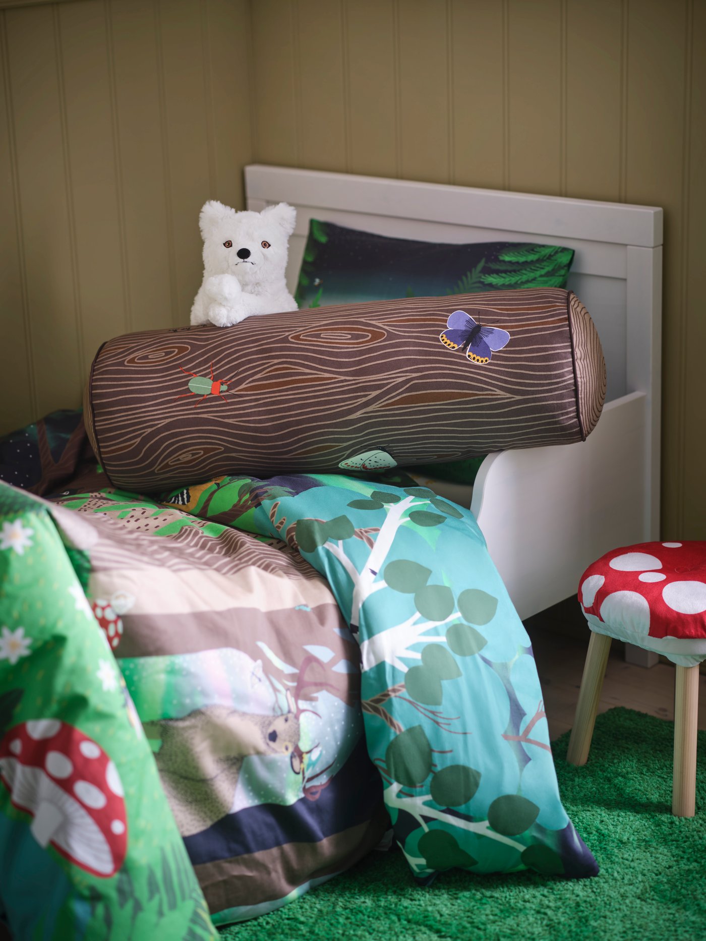 A cylinder shaped/brown SKOGSDUVA cushion in the childrens room