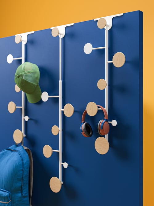 Three beige BÄRFIS door hangers, one holding a cap and a backpack, and another holding headphones, hang from a blue panel.