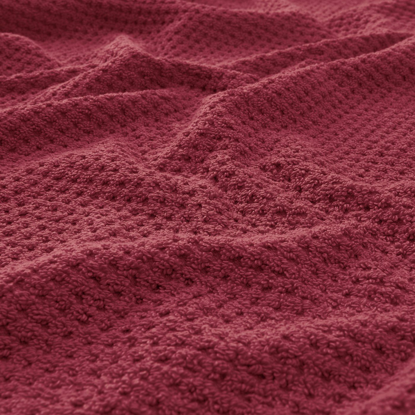 Nahaufnahme eines dunkelroten GULVIAL Handtuchs aus 100% Baumwolle.