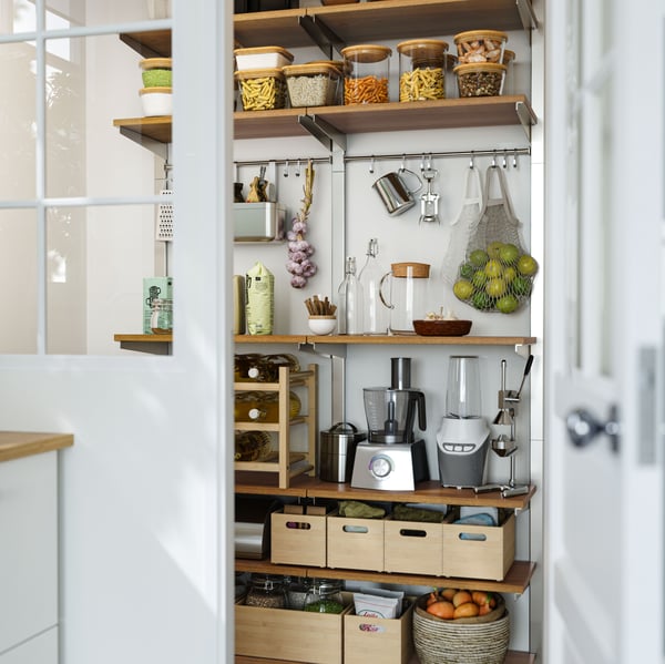 The wall of a well-organised walk-in pantry fitted with a variety of shelves, rails, jars and boxes.