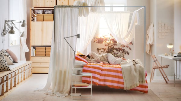 A white Luröy/Skådis white VITARNA four-poster bed frame in the bedroom