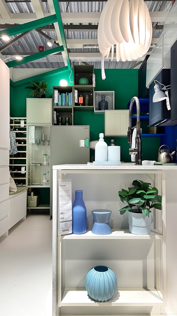 A bright, spacious kitchen with an open PLATSA cupboard with colored vases