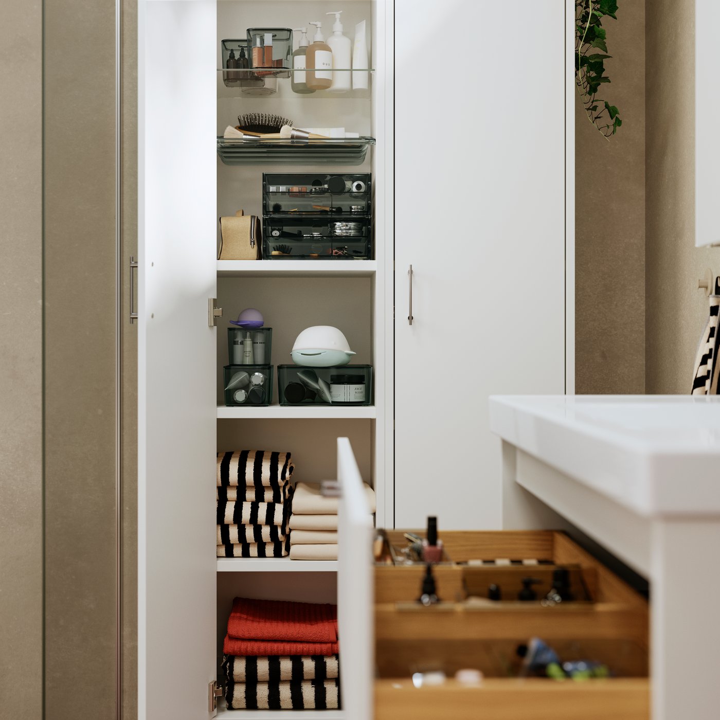 A bathroom with a white high cabinet featuring shelves and an open door, showcasing neatly arranged VISSLAÅN organisers.