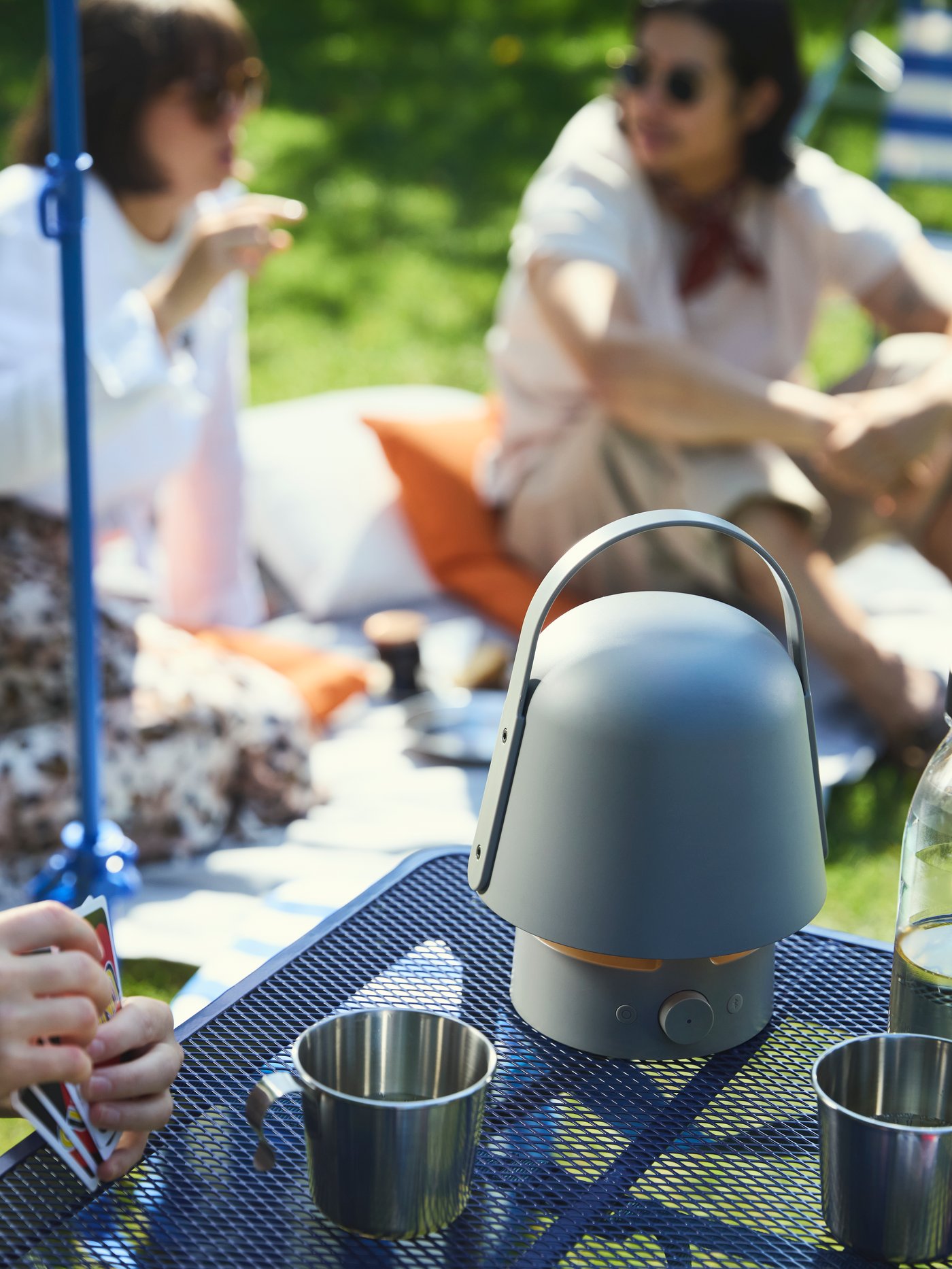 The VAPPABY Bluetooth speaker lamp sits on a table in the park, providing music for the picnic.