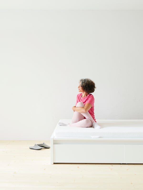 A firm/white ÅBYGDA foam mattress in the bedroom