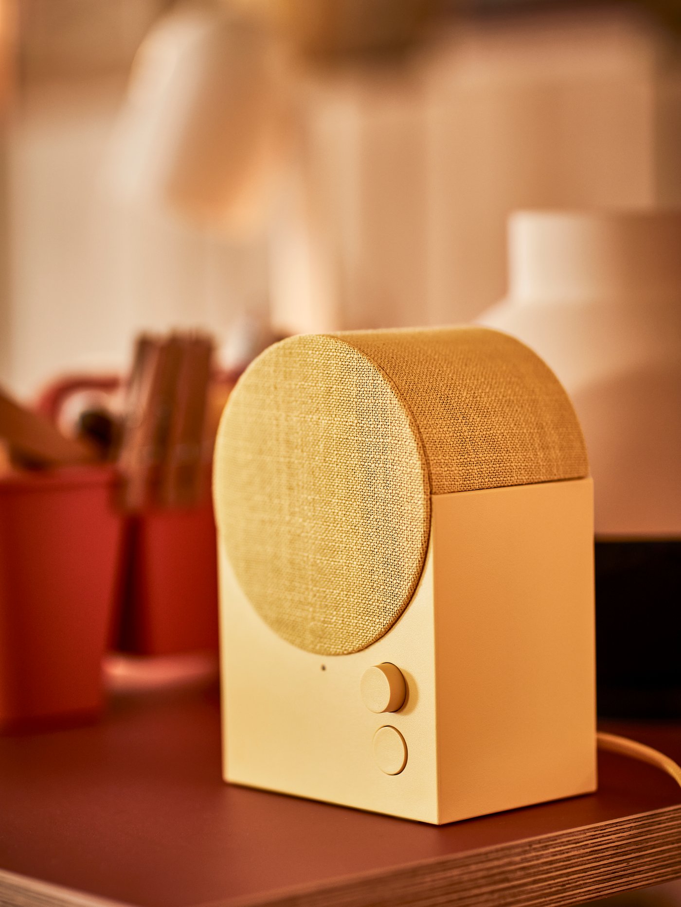 Une enceinte jaune posé sur un meuble
