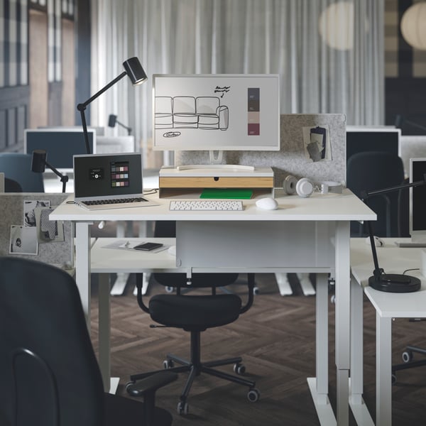 Two white TROTTEN sit/stand desks with noticeboards attached on both sides, surrounded by SMÖRKULL office chairs.