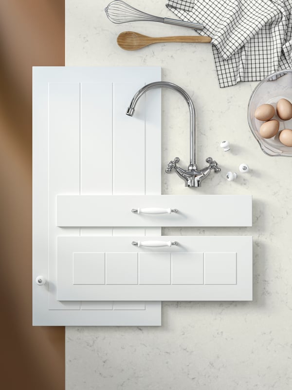 A mood board for a kitchen with a white marble worktop, white kitchen fronts, a tap and white doors with classic handles.