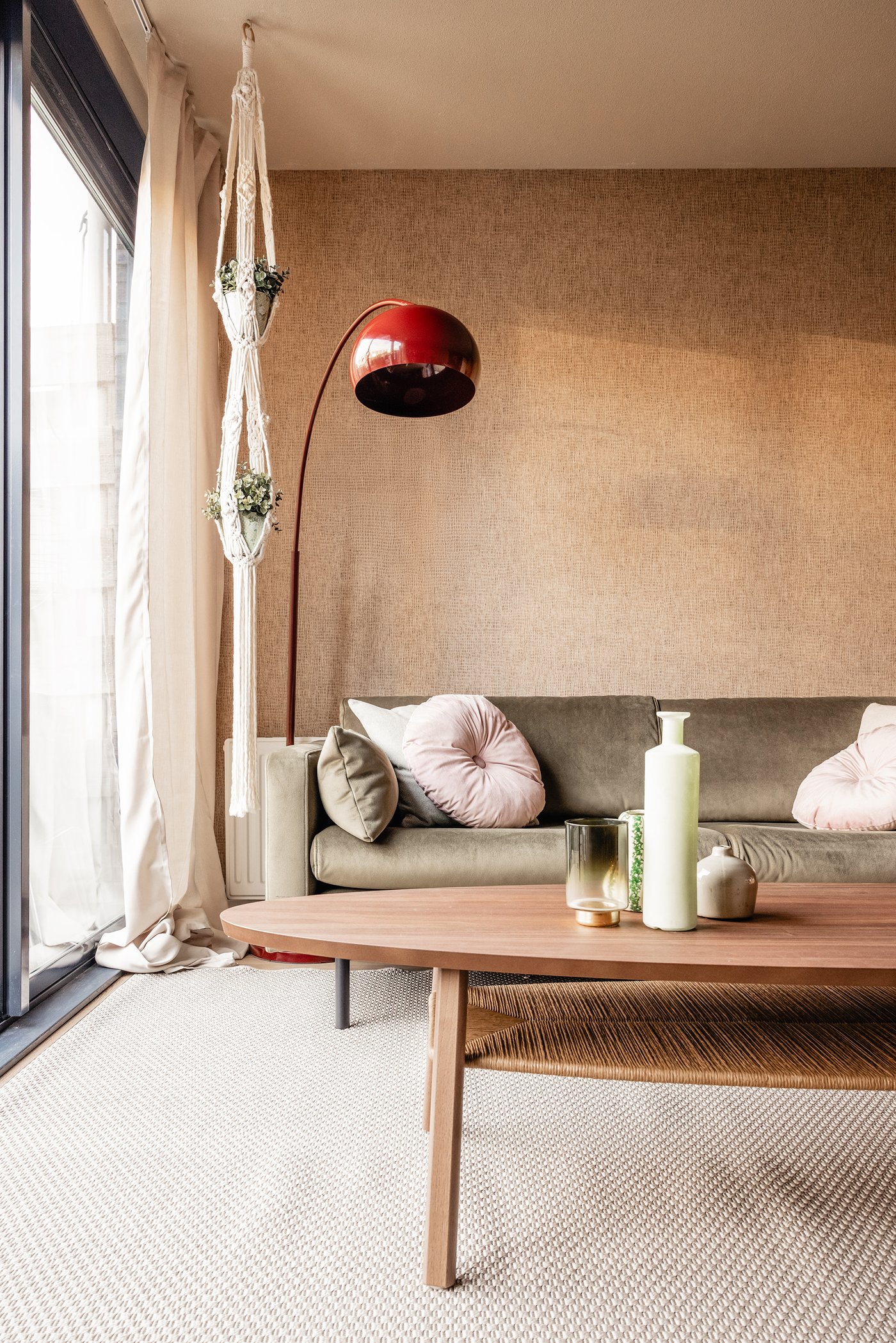 Een hoek van de woonkamer. In deze hoek staat een bank, een rode vloerlamp en een STOCKHOLM salontafel.