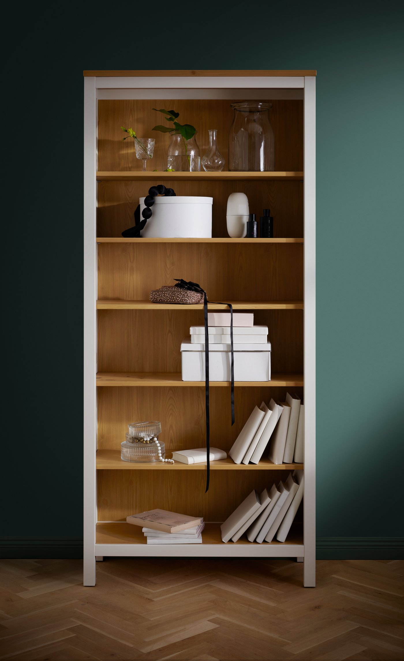 Ein weiß lasiertes/hellbraunes HEMNES Bücherregal im Wohnzimmer.