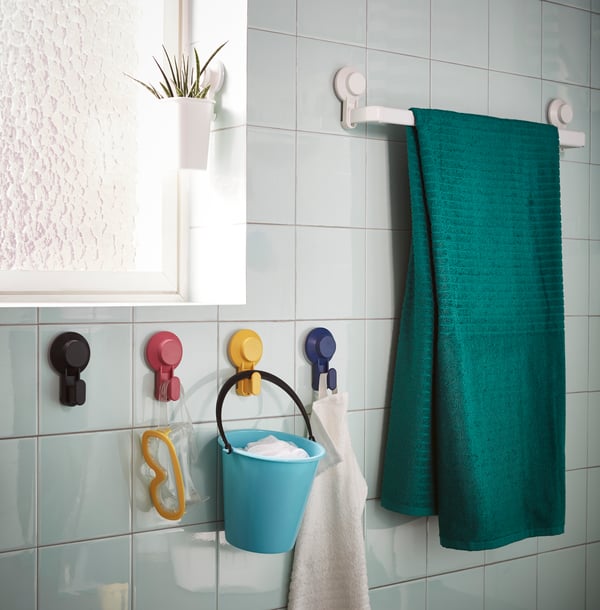 Una pared de un baño con un colgador de toallas con ventosas TISKEN 