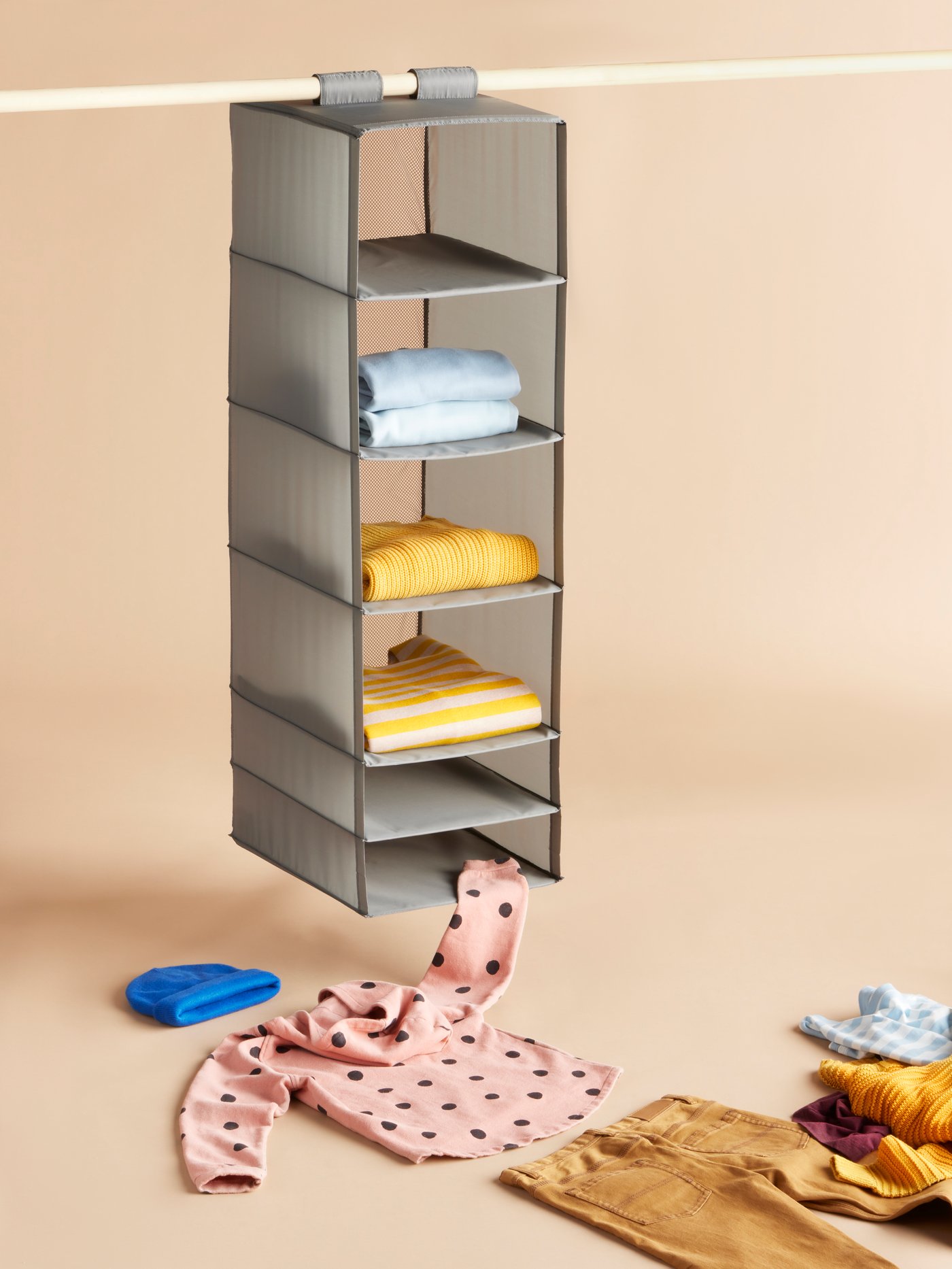 Light grey SKUBB fabric storage shelf with colourful clothes neatly folded. 