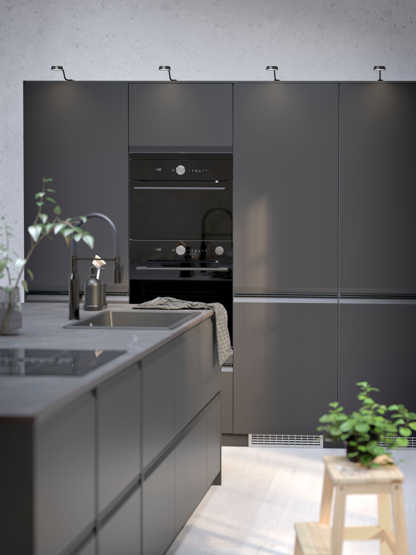 Cuisine avec un combiné micro-ondes FINSMAKARE noir à air pulsé placé au-dessus d'un four à air pulsé avec fonction de couture pyro.