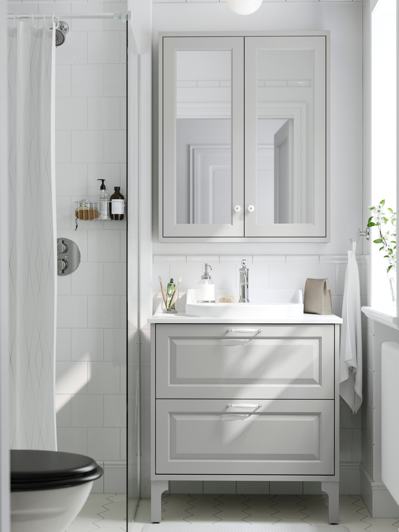 Bright bathroom with a gray vanity, mirrored cabinet and a shower with a white curtain.