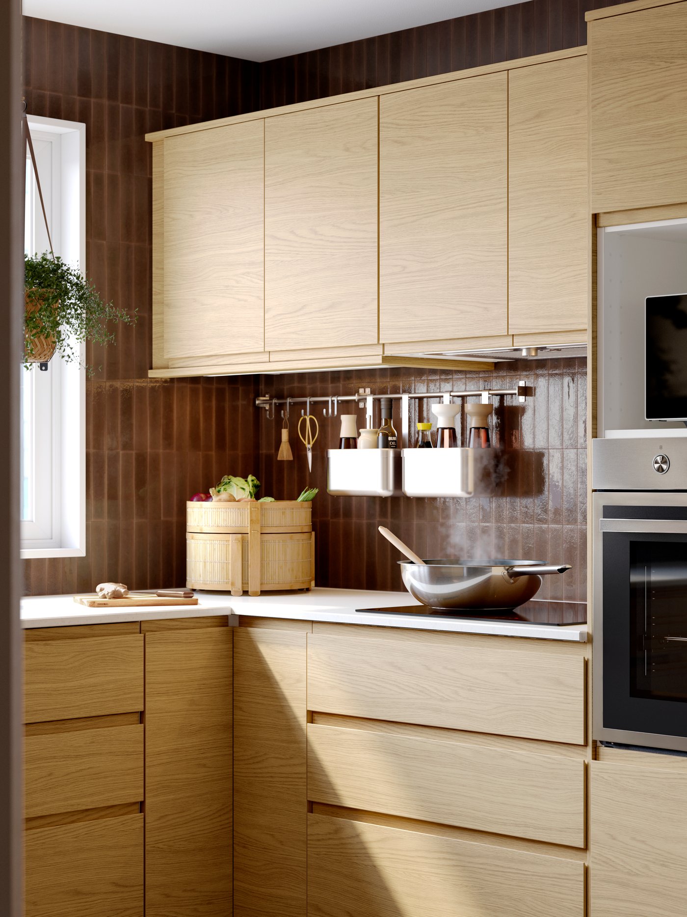 A kitchen with VOXTORP drawers fronts and doors in oak effect, ANRÄTTA forced air oven in stainless steel, baskets hanging.