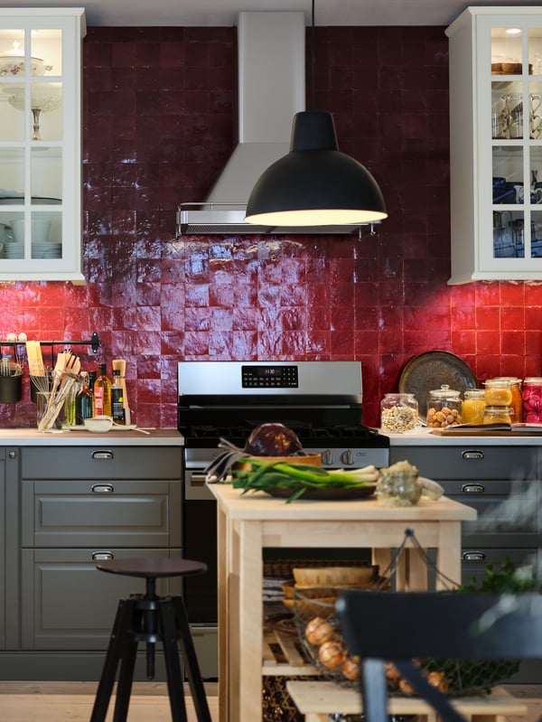 Una cocina SEKTION/MAXIMERA con una barra EKBACKEN y dos carritos de cocina BEKVÄM de abedul que crean una isla de cocina.