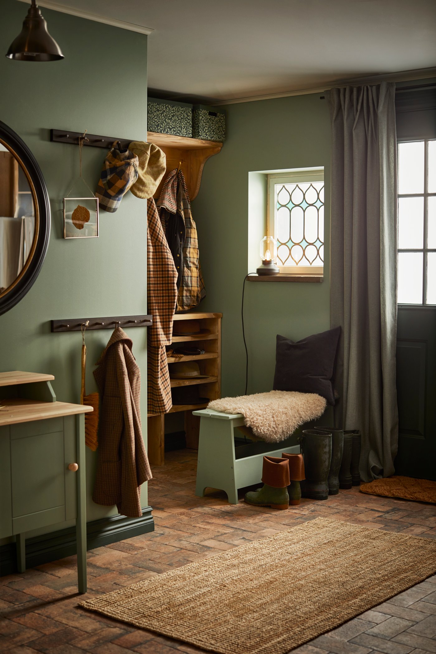 En rustikk gang med grønne vegger og et mykt teppe på gulvet.