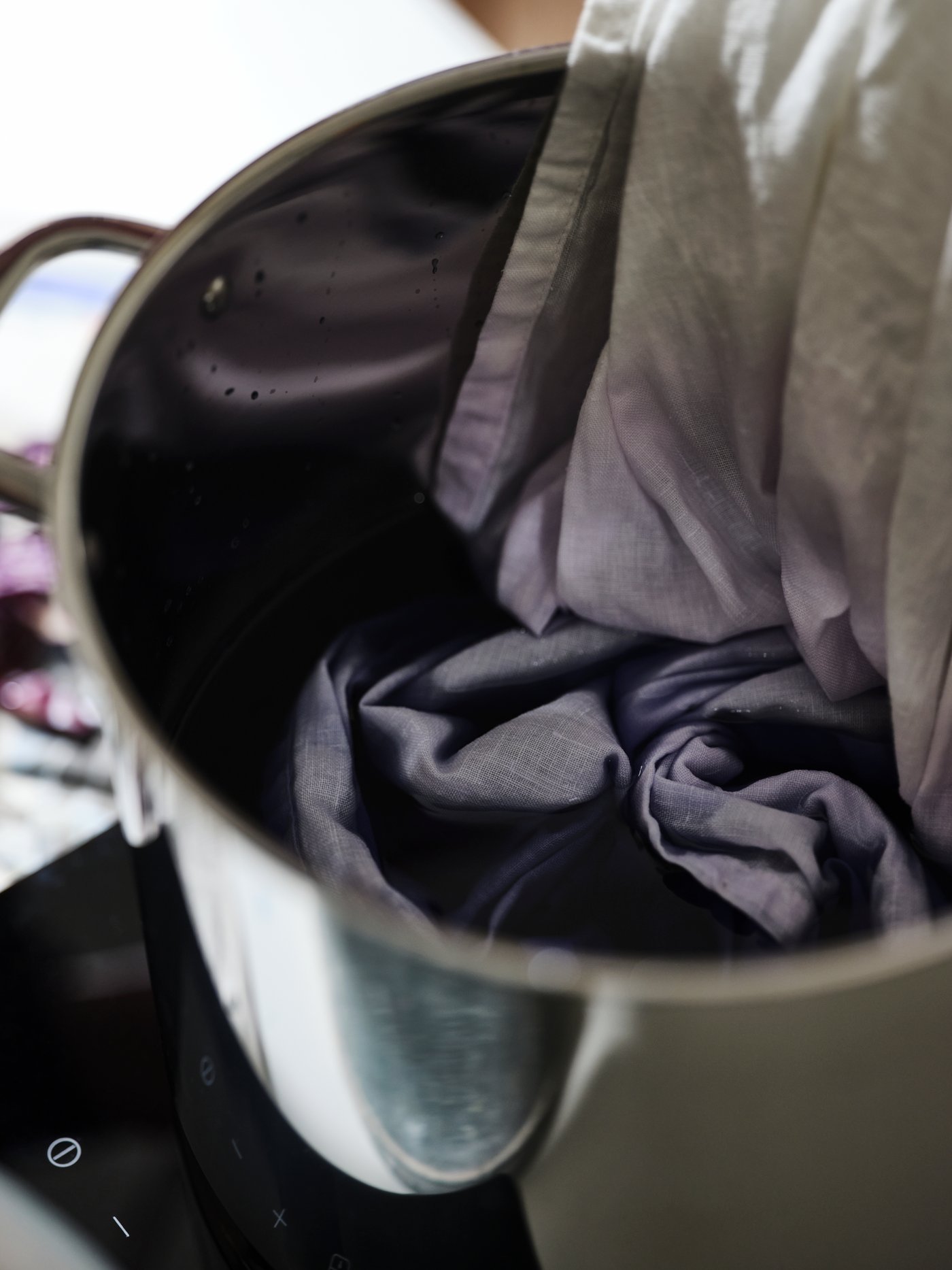 White SILVERLÖNN fabric, lowered into a dark liquid in an IKEA 365+ stockpot on a white TILLREDA portable induction hob.