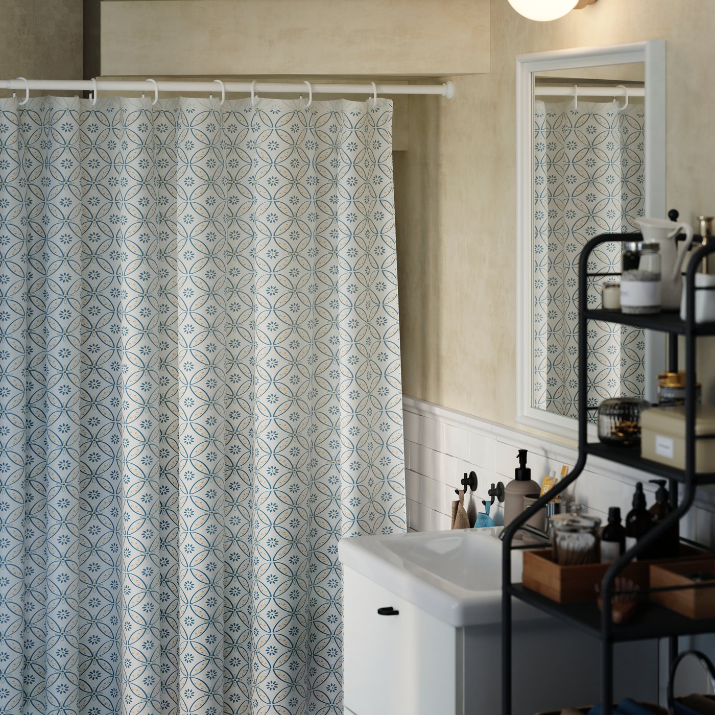 Un bastone per tenda doccia BOTAREN bianco montato sotto una scala in un bagno di servizio. Appesa al bastone, una tenda doccia nasconde alcuni scaffali.