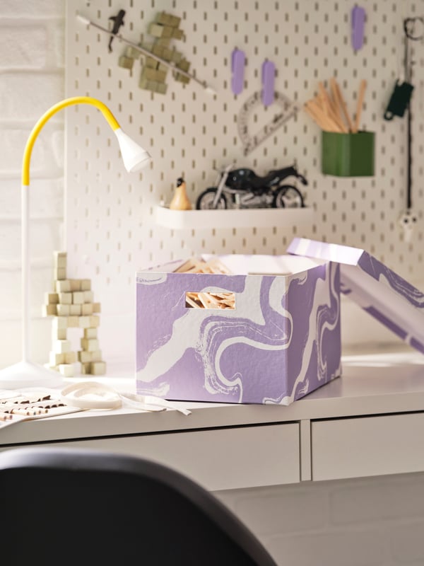 A white desk with storage boxes with lids.