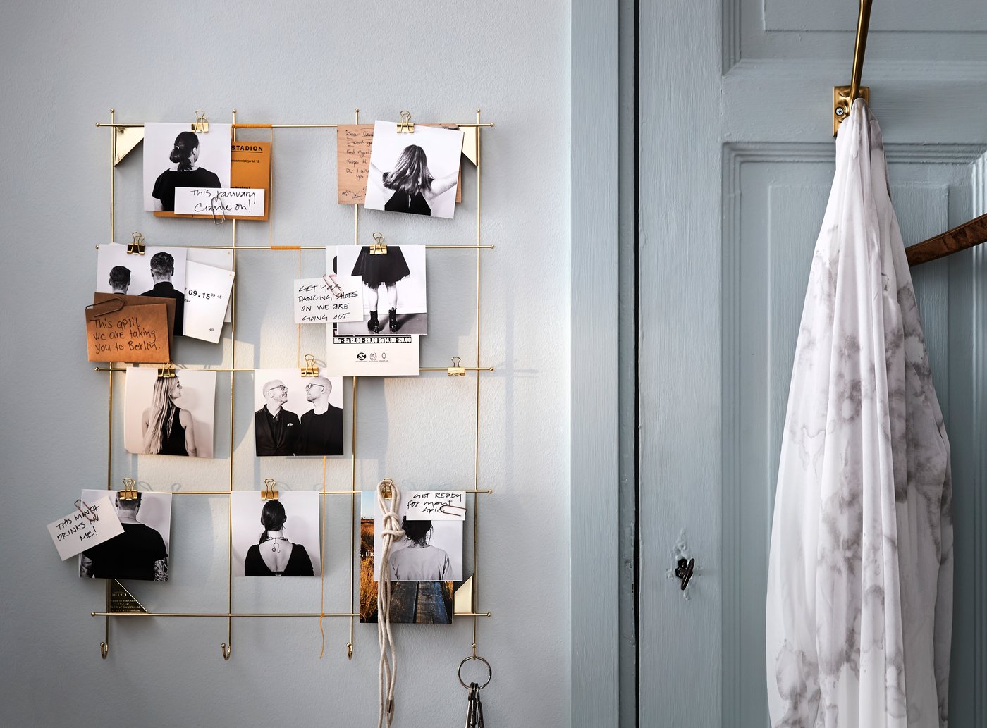 Use an IKEA MYRHEDEN brass wire frame as a DIY wall calendar or to-do list wallboard by clipping photos and handwritten goals with the included gold hooks.