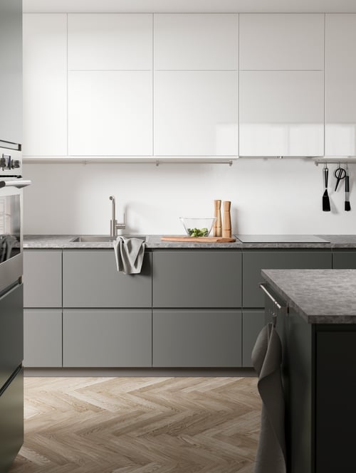 Küche mit Unterschränken, Arbeitsplatte, Wandschränken mit Türen, Spüle, Mischbatterie, Kochutensilien, Gewürzmühlen, Backofen, Handtuch.