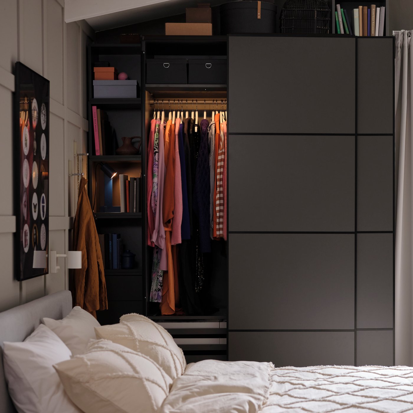 Spavaća soba s krevetom, ormarom s odjećom, bijelom foteljom i velikim prozorom s bijelim zavjesama.