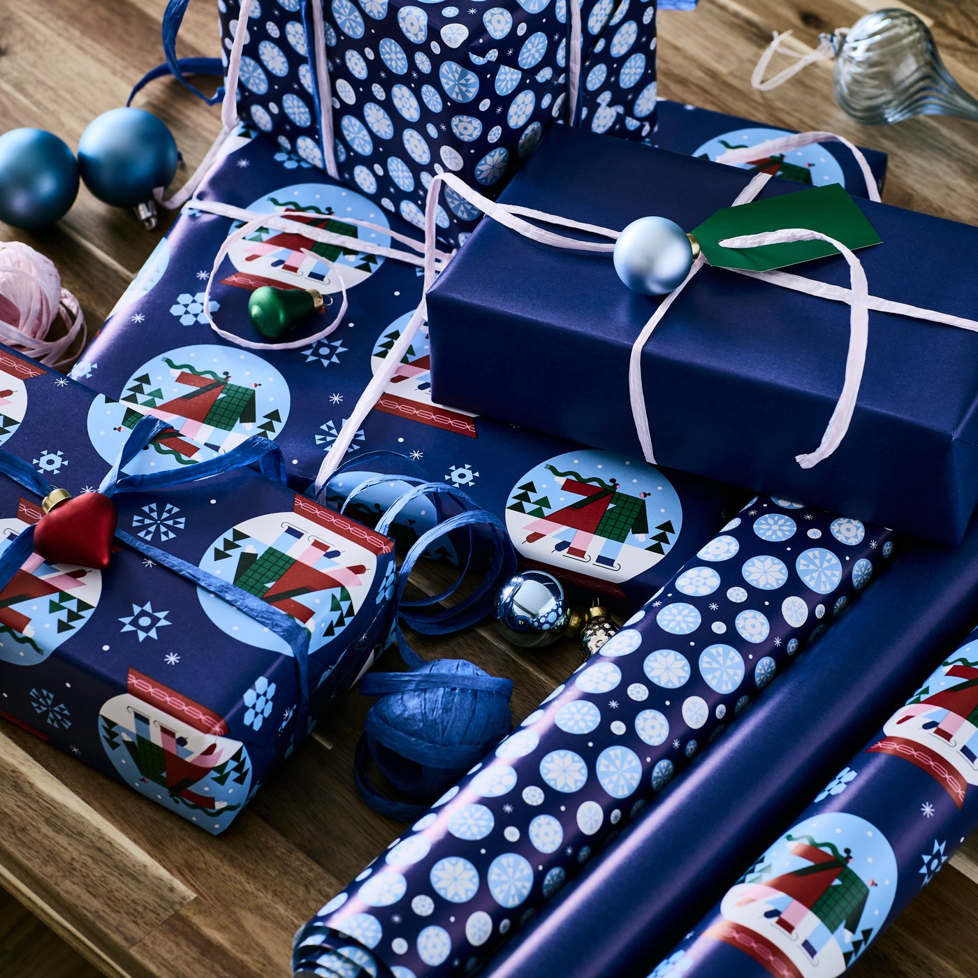 Presents are wrapped with blue-themed VINTERFINT wrapping paper in different patterns.